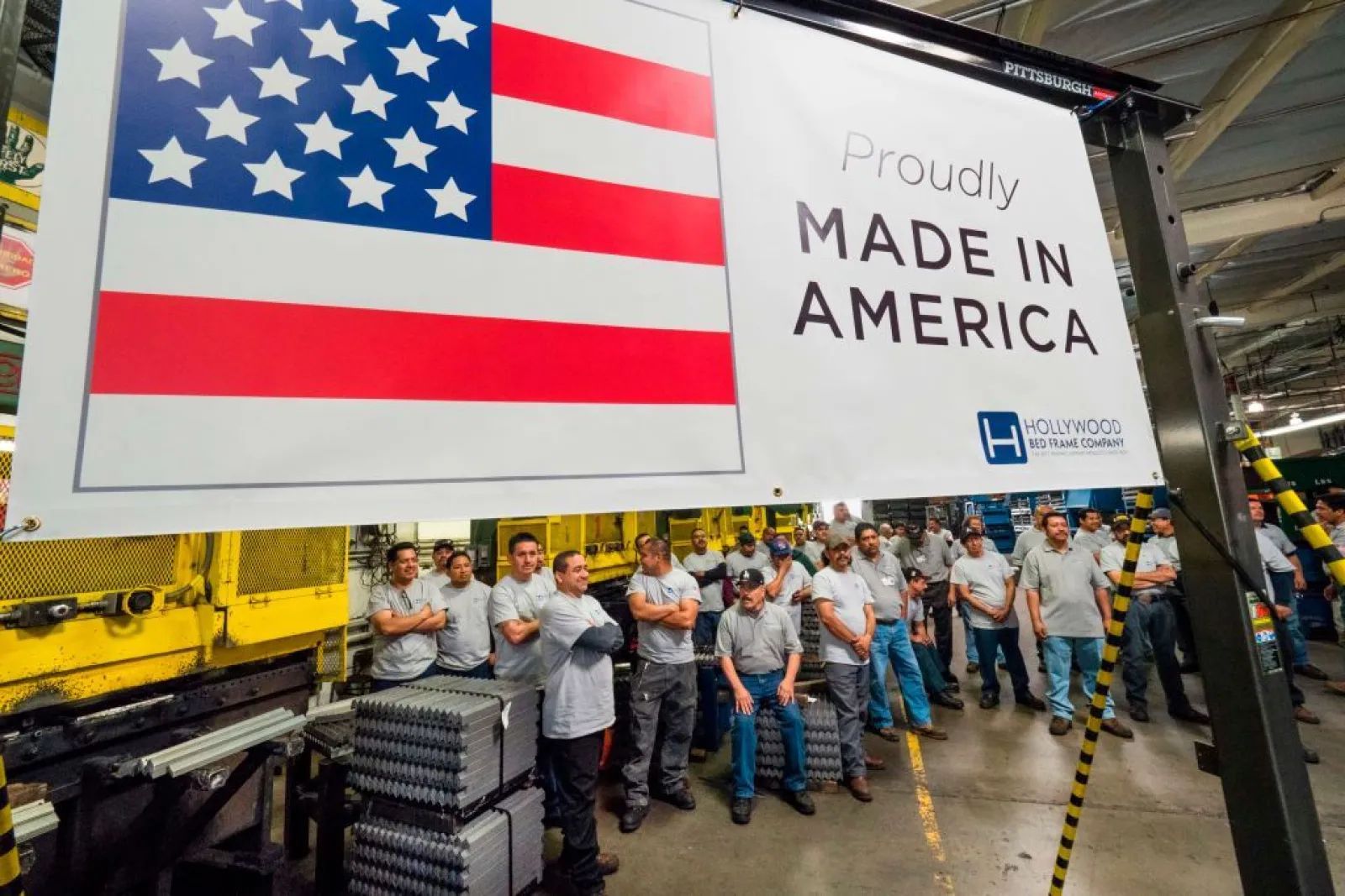 Workers gathered beneath a Proudly Made in America banner at the Hollywood Bed Frame Company factory